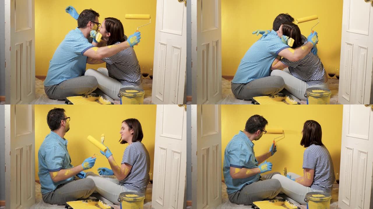 疲惫的男女夫妇坐在地板上。他们在情感上拥抱，并在工作结束时感到高兴。油漆修复工作超过了概念。慢动作