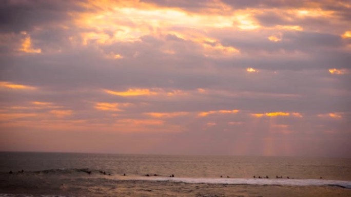 神奇的日落期间海洋中的冲浪者