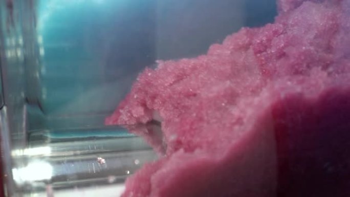 冰镇冰糕机器混合果汁。冰冻的雪泥四处旋转，夏季款待。用甜味剂压碎的冰镇