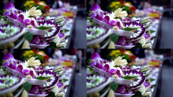 亚洲寺庙祭祀用的花。模糊的背景是崇拜者。主题在左边。