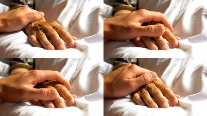 面目全非的忧心忡忡的人轻轻地抚摸着生病的祖母给予支持的手。儿子安慰躺在医院床上的年迈妈妈皱巴巴的手臂