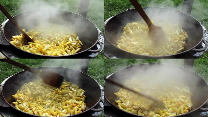 炸薯条在篝火上在森林的大锅中油炸。用油油炸的土豆。煮土豆。镜头1080p.视频