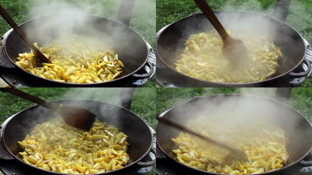 炸薯条在篝火上在森林的大锅中油炸。用油油炸的土豆。煮土豆。镜头1080p.视频