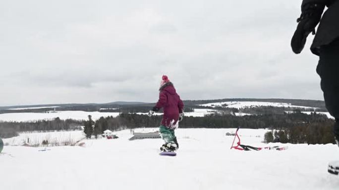 孙女和祖母滑雪板孩子雪山玩耍