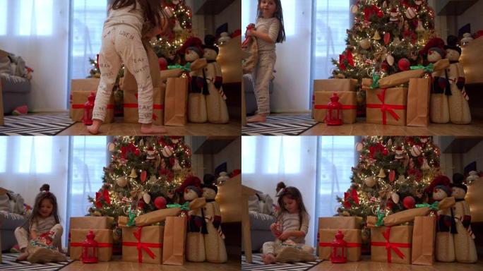 穿着睡衣的可爱孩子在圣诞节早上打开礼品袋