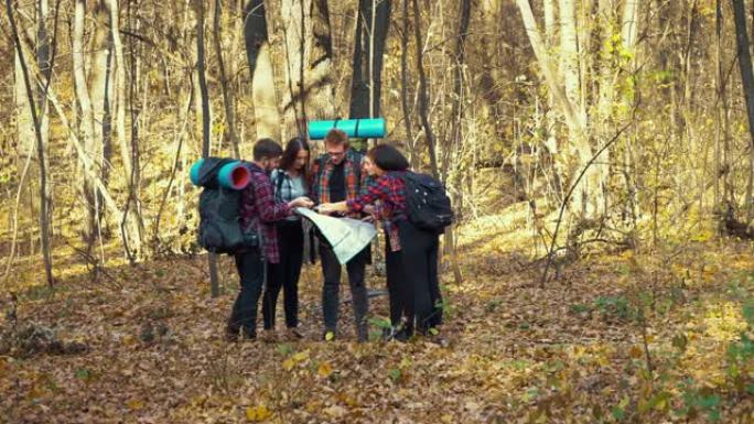 徒步旅行者在秋天的森林中查看纸质地图