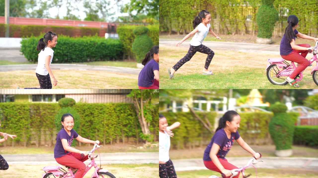 两个亚洲小女孩在花园里骑自行车