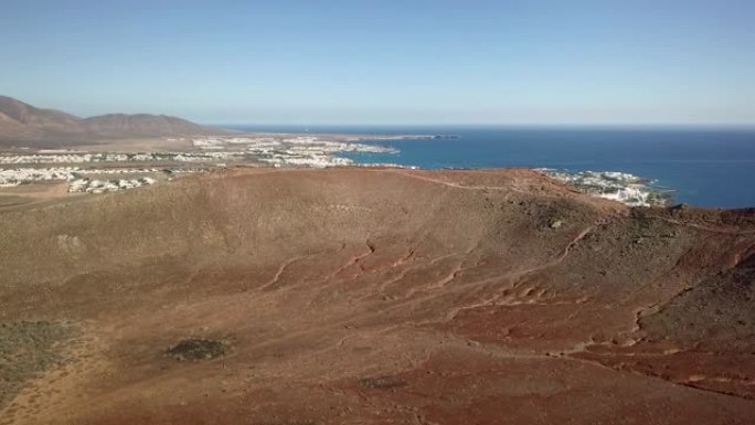 火山火山口市中心前面的红山兰萨罗特岛的白色海滩