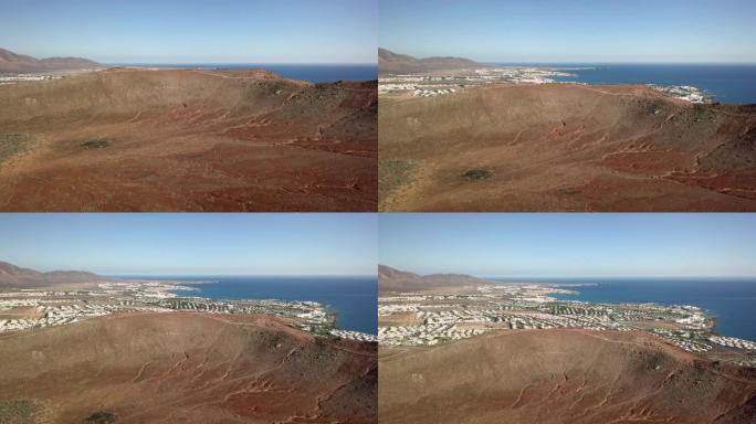 火山火山口市中心前面的红山兰萨罗特岛的白色海滩