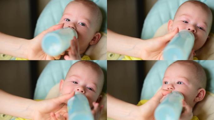 母亲用奶瓶中的婴儿配方奶粉喂养婴儿