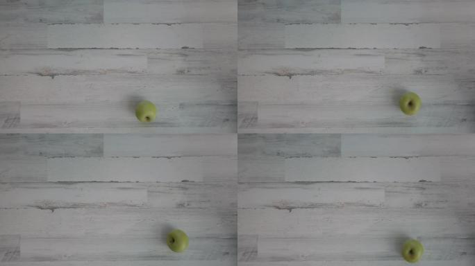 青苹果旋转白色木地板或桌子，自上而下，拍摄4k。
