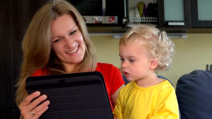有小女儿的母亲在平板电脑上开始与父亲进行视频对话