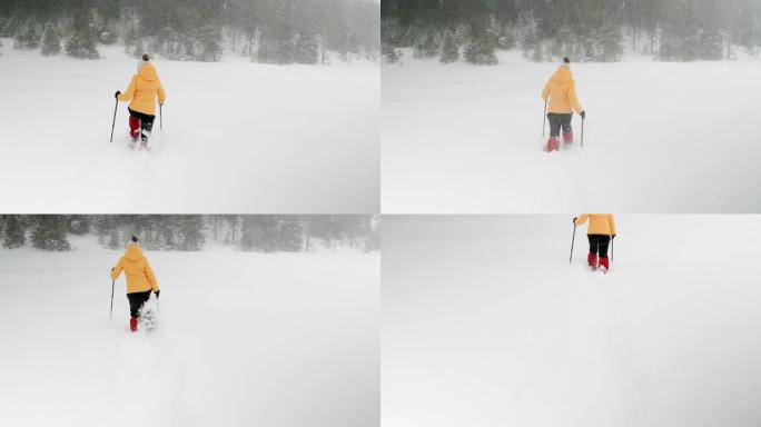 冬季旅行者。年轻的游客雪鞋在深雪中行走，享受冬季的山峰。