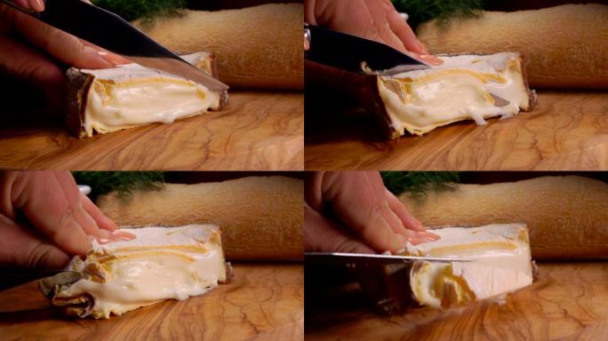 用小刀在木板上切的奶油法国Epoisses奶酪