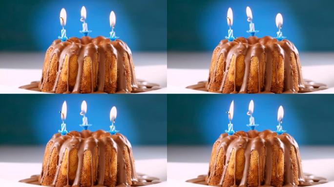 在大理石蛋糕上燃烧蓝色生日蜡烛，配巧克力牛轧糖糖霜