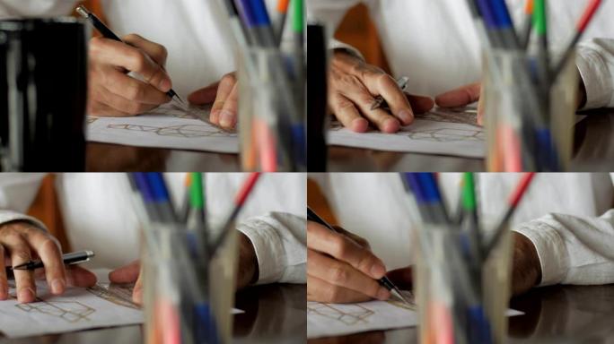 设计师多莉在凌乱的桌子上用铅笔和纸手工设计