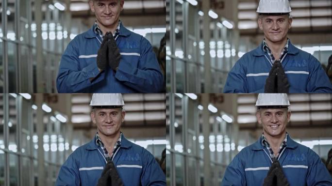 工厂人用手打招呼，以工作愉快的微笑表示敬意。安全帽有助于机械师工作期间的安全。非接触式问候语有助于防