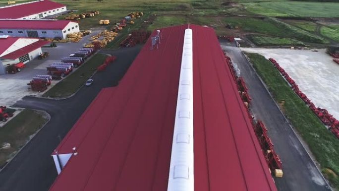 工业工厂的领土。红色屋顶的大型机库。鸟瞰图，晚间拍摄