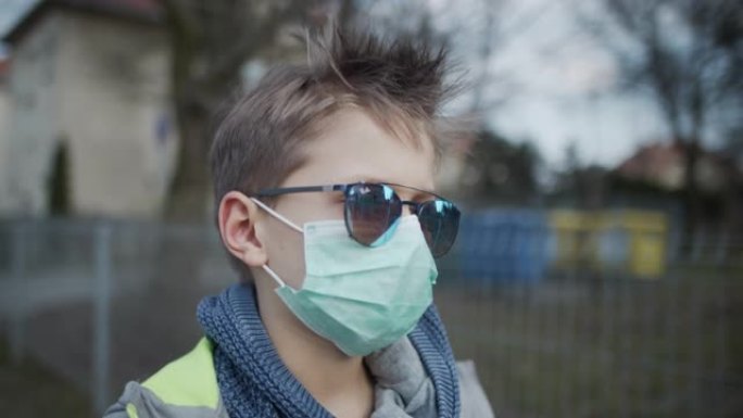 戴着防病毒面具的小男孩正在户外散步