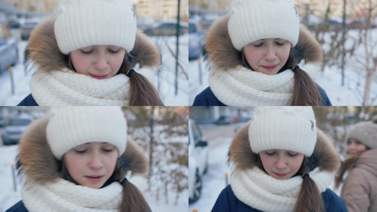 肖像让年轻女孩在冬天的街道上哭泣。特写脸不快乐的女孩在雪城街上冬天散步时哭泣。