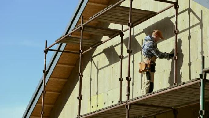 建筑工人整理房屋侧壁保温。