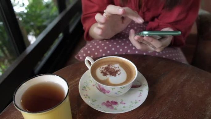 在咖啡店使用智能手机的女人。