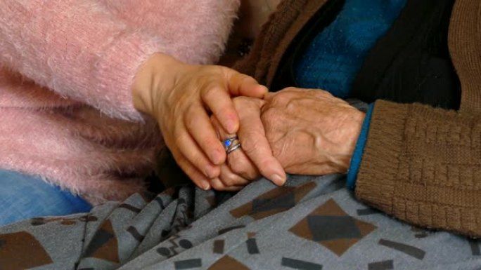 表示对老年人的尊重。一个年轻的女人温柔地抚摸着老人，老妇人正在等待同情，