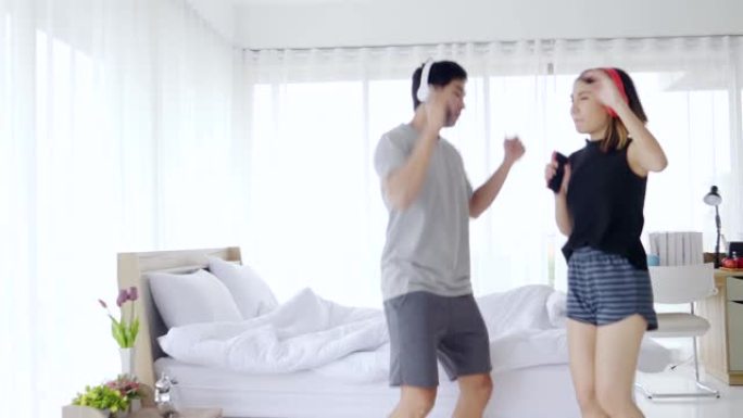 亚洲夫妇在卧室里跳舞快乐地庆祝