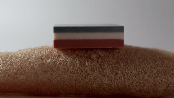 丝瓜上的三色肥皂用于白色背景上的淋浴。