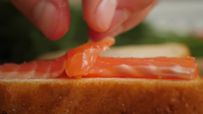 健康饮食海鲜欧米茄3。木板上的红鱼鲑鱼特写。厨师用红鱼做三明治，美味的肉慢动作。宏观厨师鲑鱼片烹饪寿