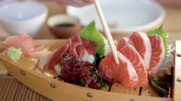 吃鲑鱼生鱼片。三文鱼生食一次性筷子