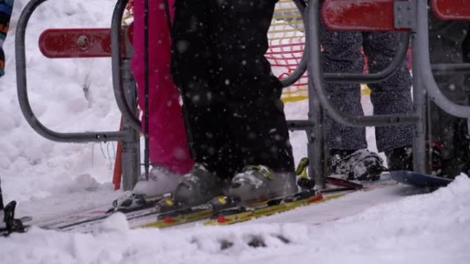 滑雪者通过滑雪缆车的旋转栅门。滑雪椅的入口举着滑雪者。慢动作