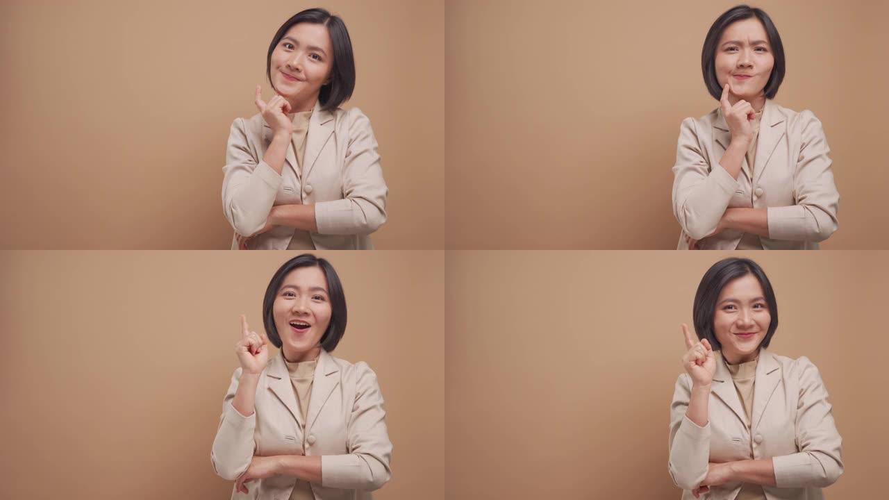 快乐的商业亚洲女人有一个好主意交叉双臂站在米色背景上孤立的复制空间。4k视频