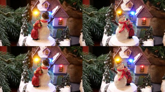 微型圣诞装饰的房子，有跳舞的玩偶和雪人。