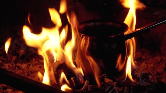 站在红色火焰的舌头所包围的煤上，用咖啡煮熟的土耳其人