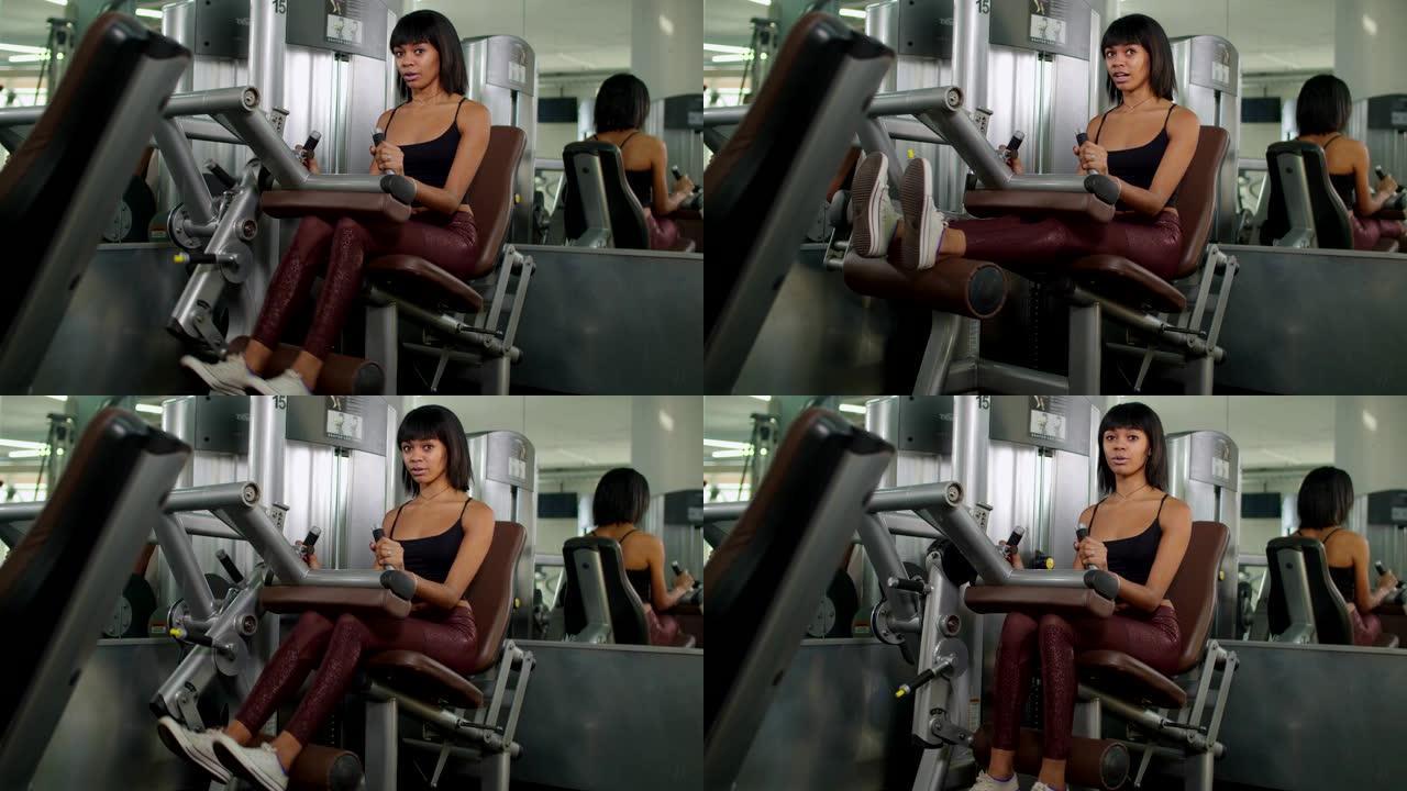 女人在健身房用伸腿机锻炼
