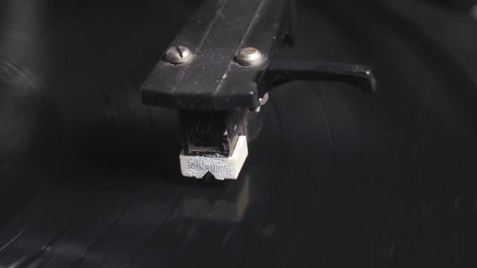 针在复古风格的旋转黑胶唱片上的特写镜头。特写选择性聚焦。复古怀旧。