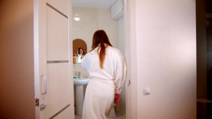 一个年轻女子穿着浴袍在浴室里散步