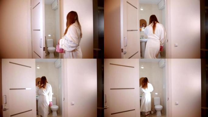 一个年轻女子穿着浴袍在浴室里散步
