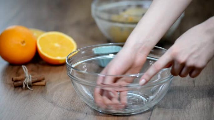 特写女性手把酵母面团放在一个上油的碗里。