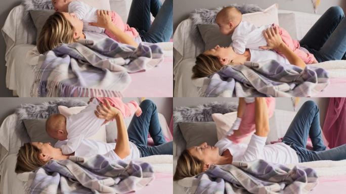 婴儿在午睡前与妈妈在床上玩耍和拥抱