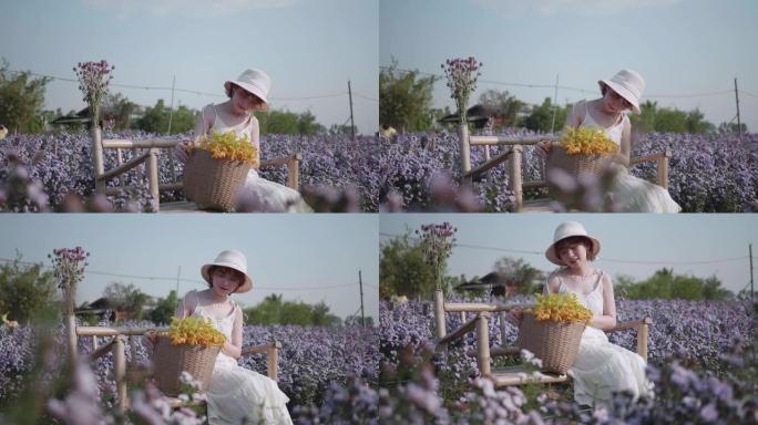 夕阳下黄紫色花田的快乐女孩