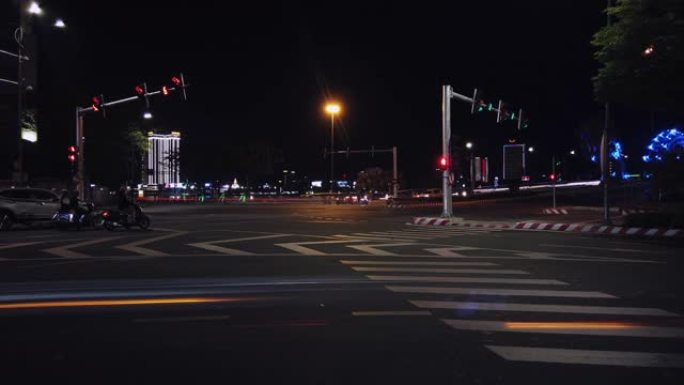 越南岘港-2020年3月12日: 夜间繁忙交通的2个延时。摩托车，汽车在十字路口行驶。大城市。大城市