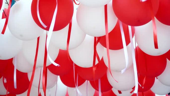 红色和白色的气球悬挂在天花板上庆祝。