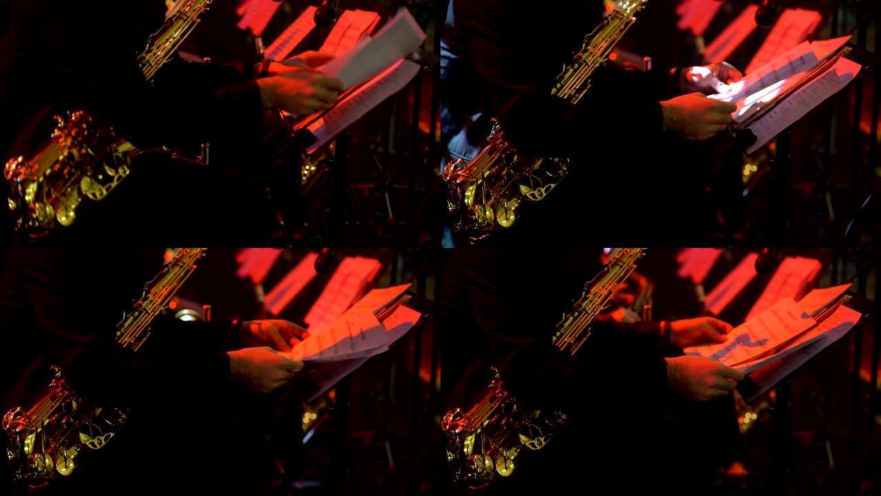穿着晚礼服的萨克斯演奏家在金色萨克斯管上演奏。现场表演。爵士音乐。