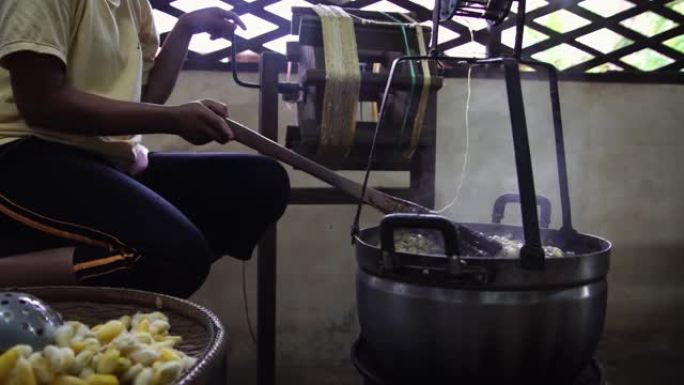 蚕茧沸腾。卷丝，将丝线与蚕茧分离。村工厂手工制作的生丝。