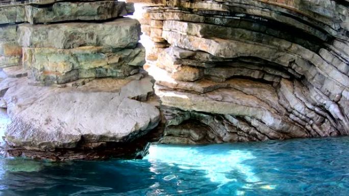 洞穴中的层状岩石和明亮清澈的海水