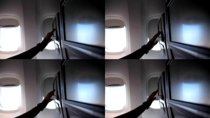 女人的手触摸飞机特写镜头中的座椅靠背屏幕