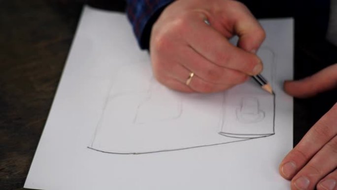 用铅笔的制革工在车间里画了一张袋子的草图。