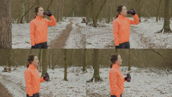 运动员训练后吞下水。女跑步者在户外运动后喝水或等渗。女人跑步后从瓶子里喝水。越野跑概念